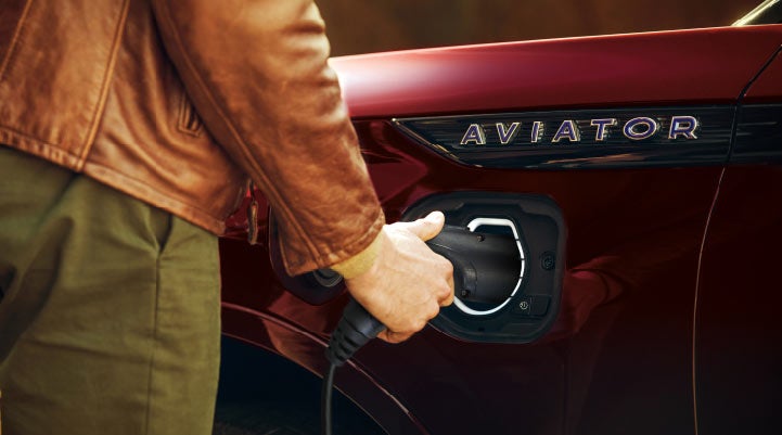 A hand is shown plugging in the charger into the charging port of a 2021 Lincoln Aviator | Mark Ficken Lincoln in Charlotte NC
